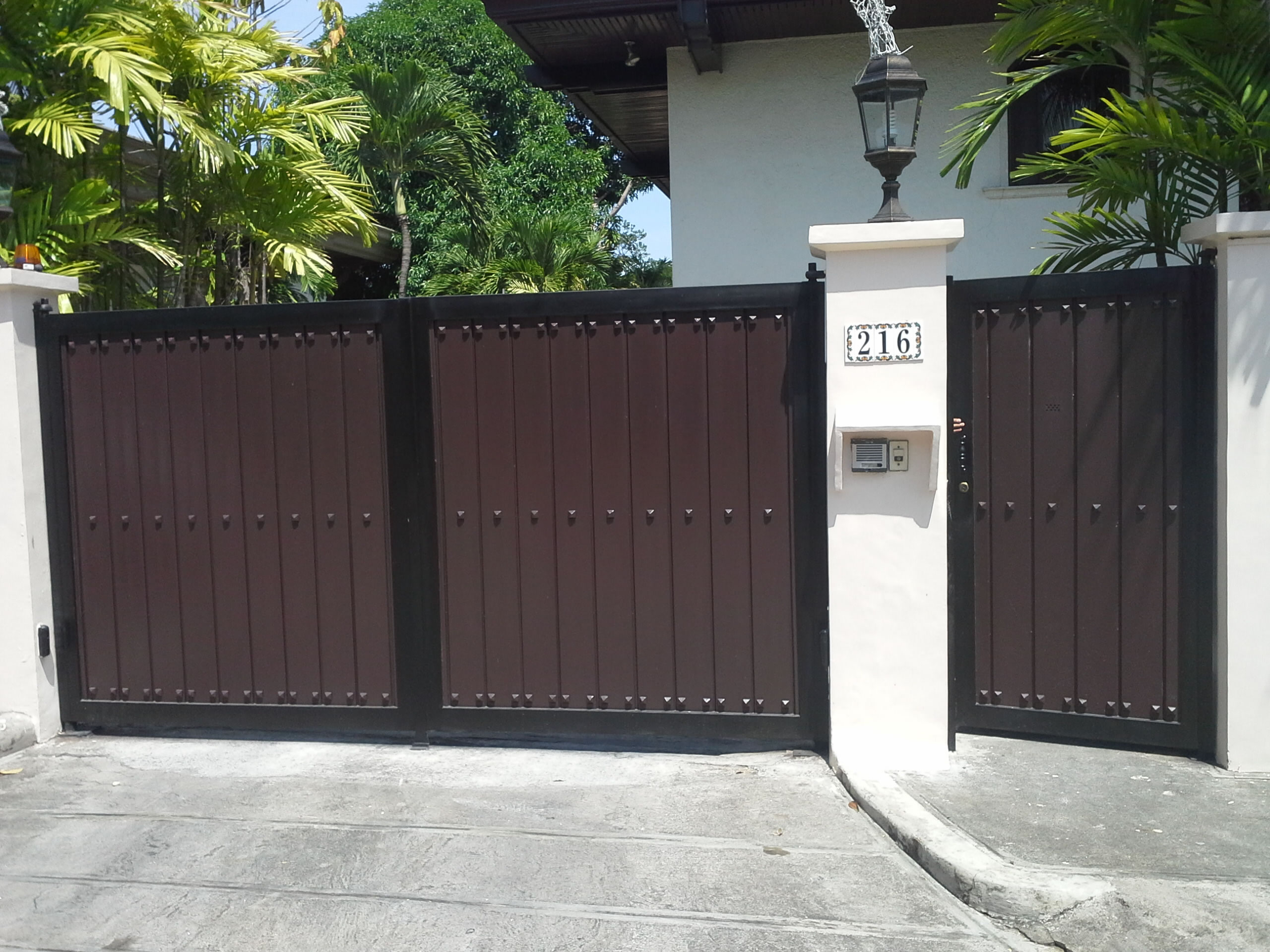 Gate in wood finish and wrought iron frame and studs accent.